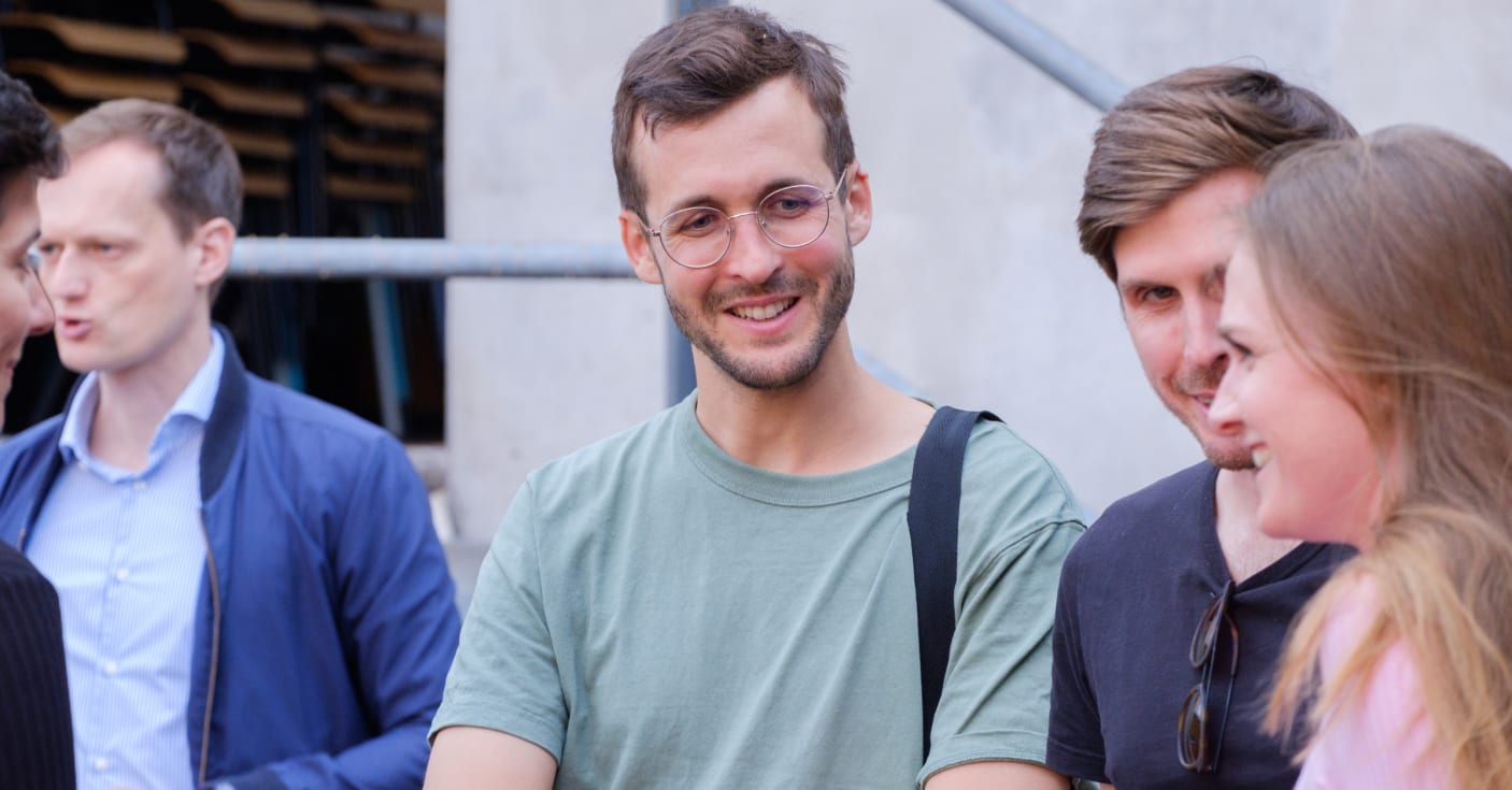 Foto ForTomorrow Sommerfest, drei Menschen sprechen miteinander