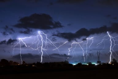 Foto eines Gewitters bei Nacht, Blitze schießen aus dem Himmel.