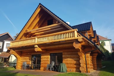 Ein Holzhaus steht da, blauer Himmel im Hintergrund