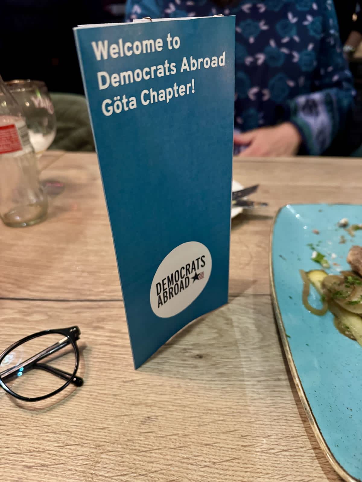 A tabletop sign announcing "welcome to Democrats Abroad Göta Chapter!"