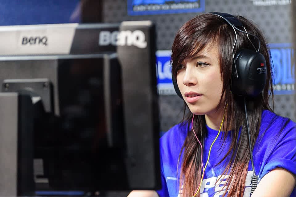 A person sitting in front of a computer wearing a headset.