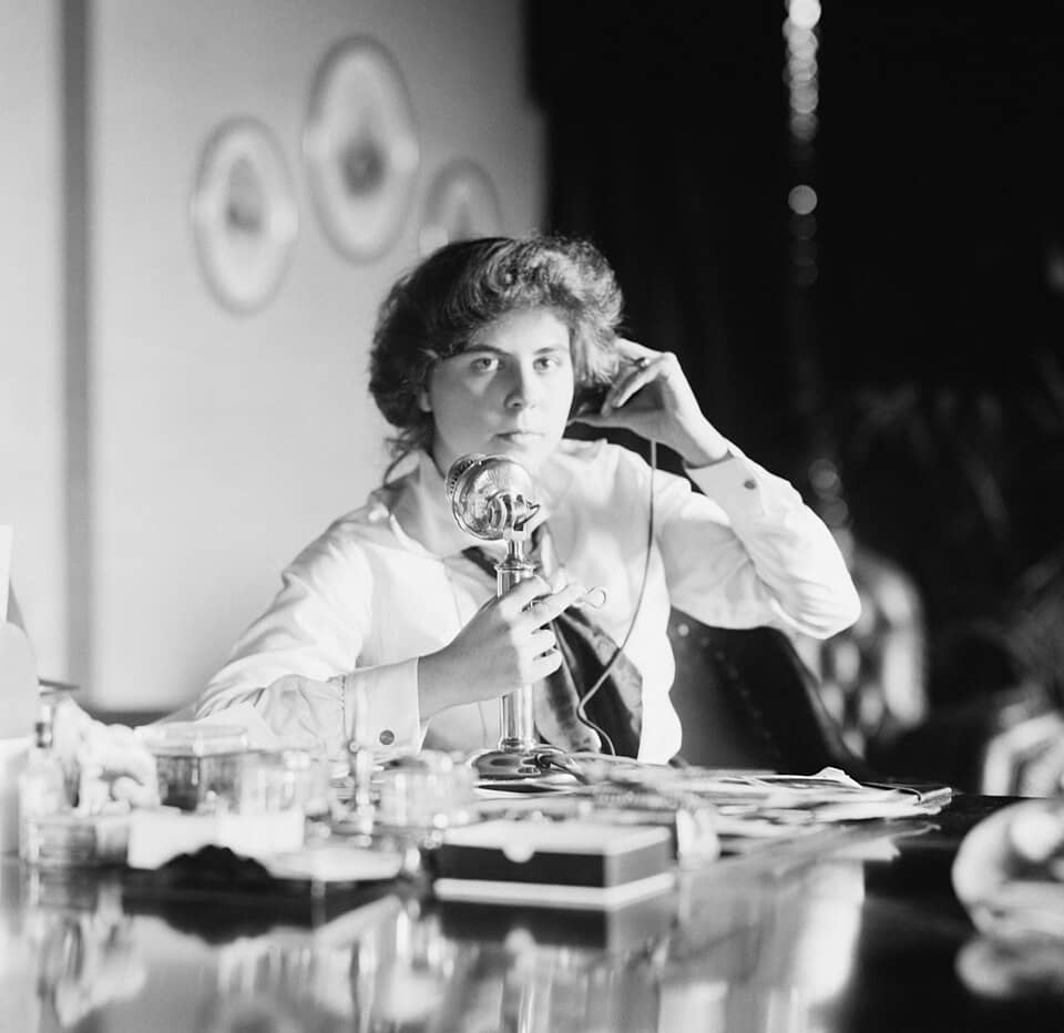 A picture of a person making a call on an old-fashioned phone.