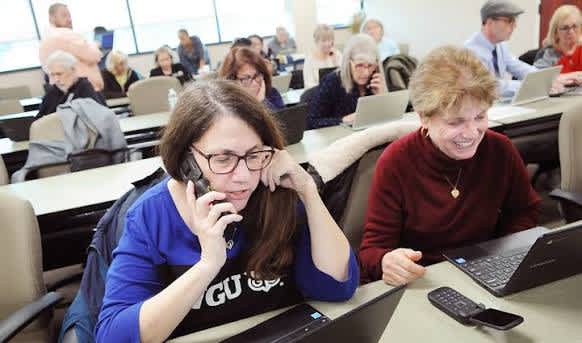 A picture of two people phone banking.