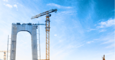 Bridge under construction with crane against blue sky