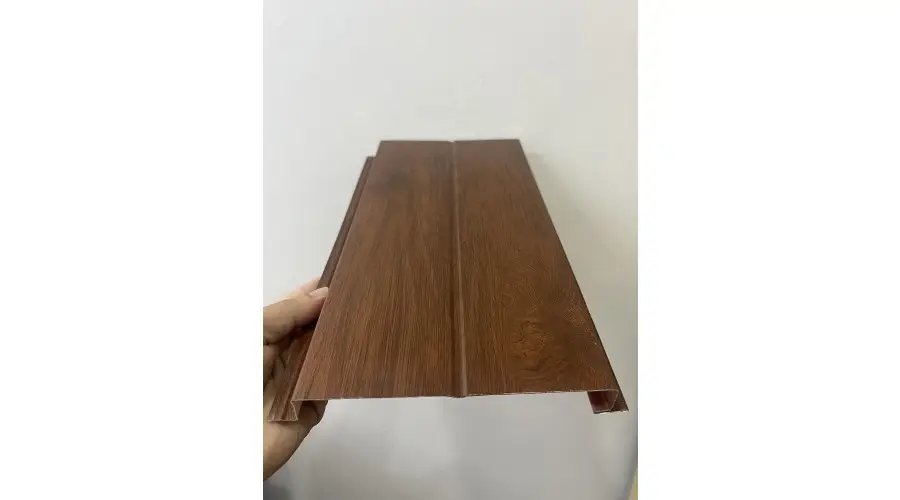 Mẫu thanh ốp màu nâu và mặt cắt đầu thanh được cầm trên tay