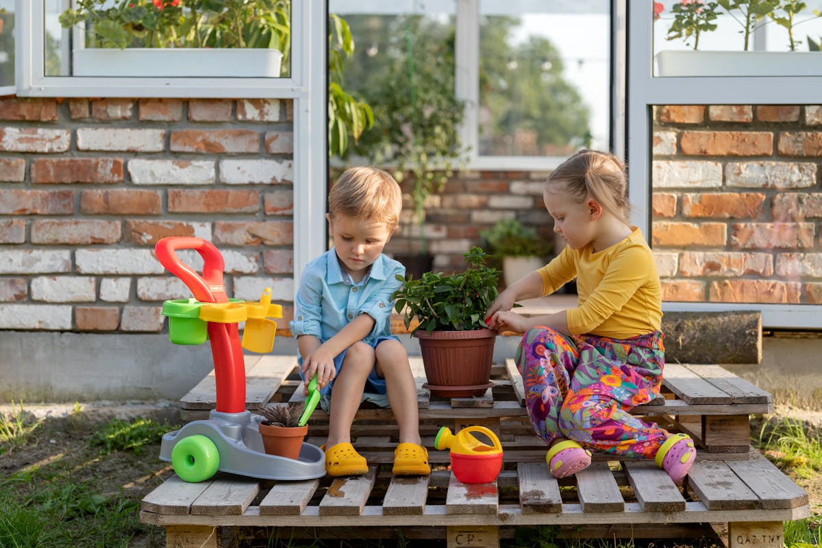 Kinder spielen im Garten mit verschiedenen Gartenspielzeugen und genießen den Sommer
