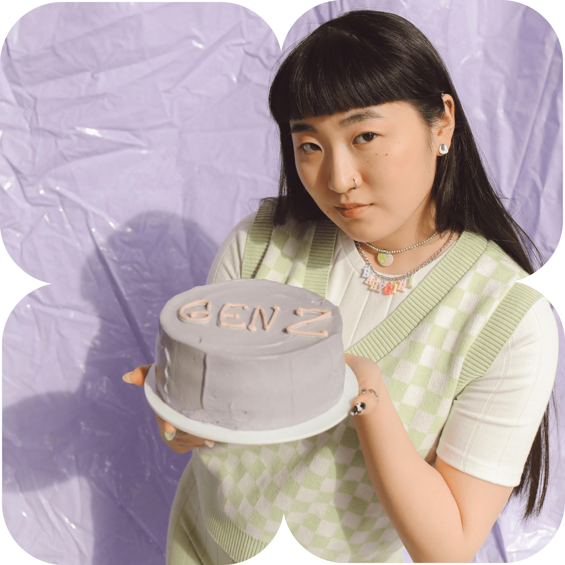 Dos mujeres jóvenes, una con una boina y la otra con cabello negro, sentadas en un ambiente decorado y observando un pastel con la inscripción GEN Z.