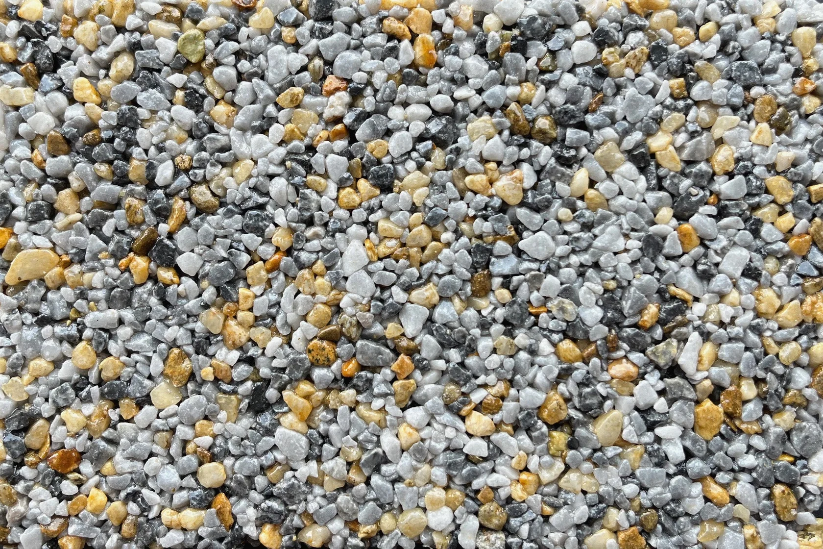 A close-up view of gray and gold vuba stone aggregate texture suitable for resin-bound flooring applications.