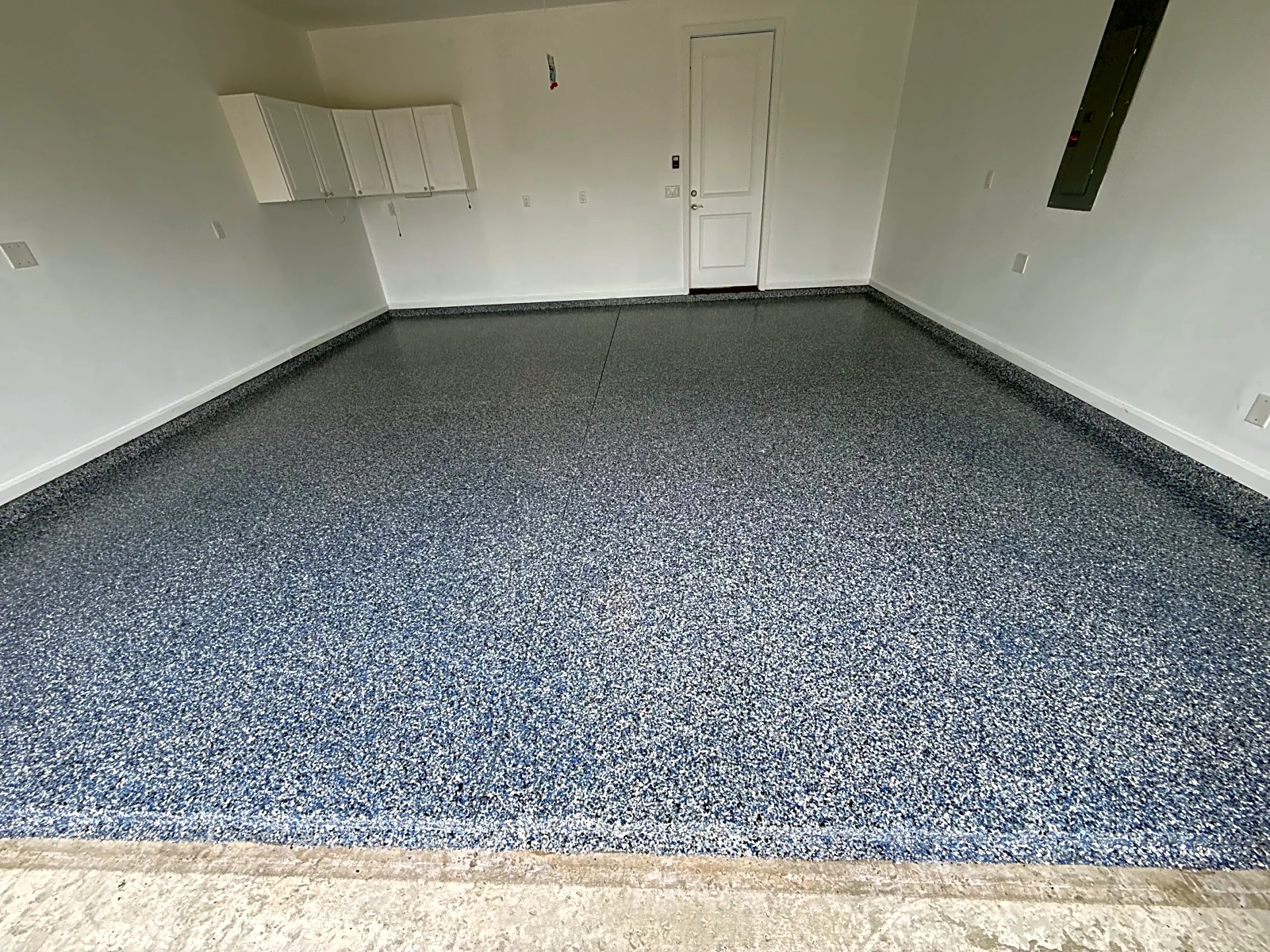 A newly coated blue flake garage floor showcasing a glossy finish in Lowcountry.
