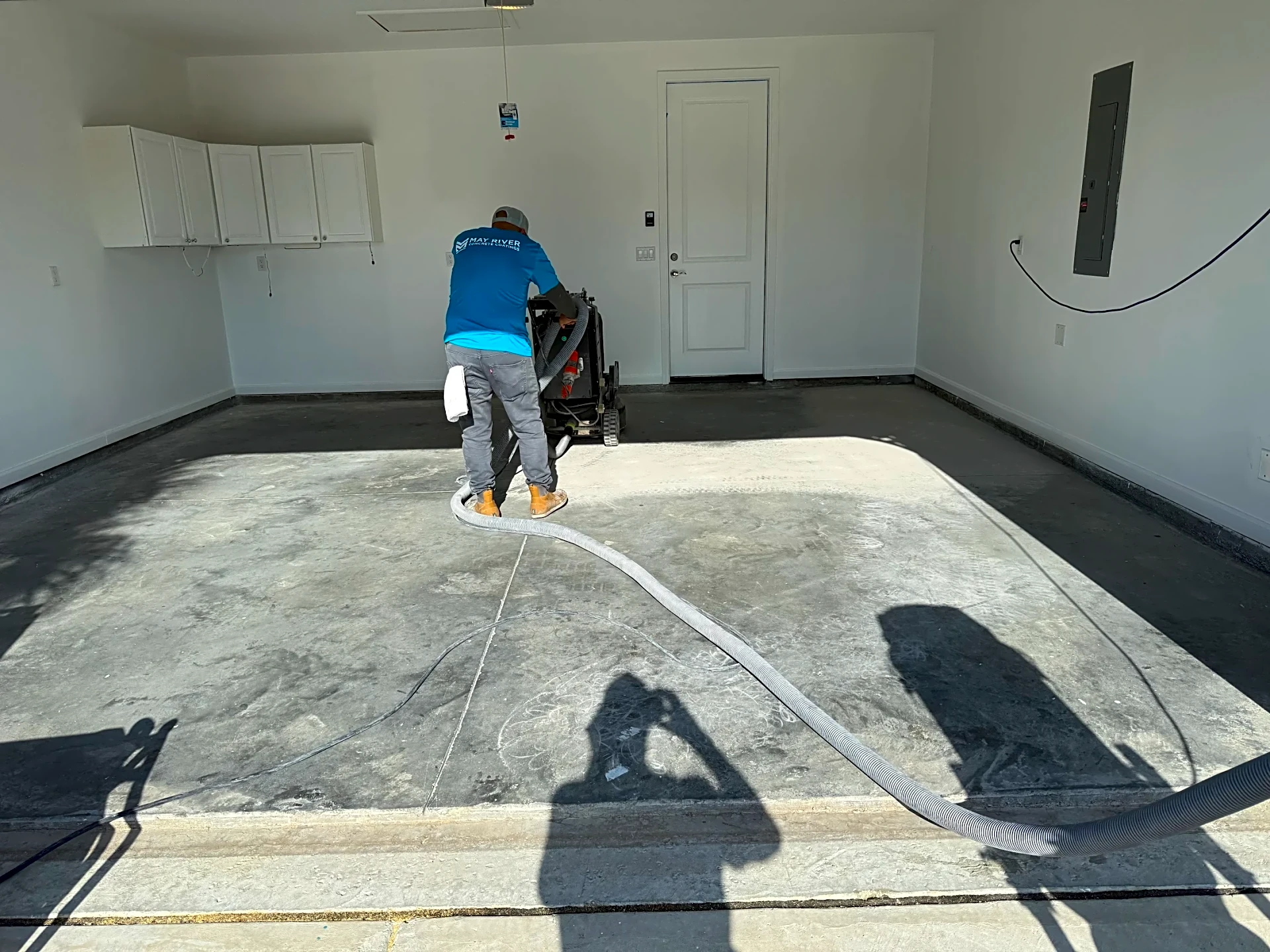 A technician preparing a garage floor for coating in Lowcountry, showcasing a clean workspace.