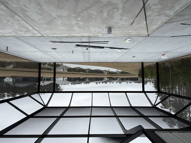 A screened enclosure under construction with a view of a tranquil water body in South Carolina.