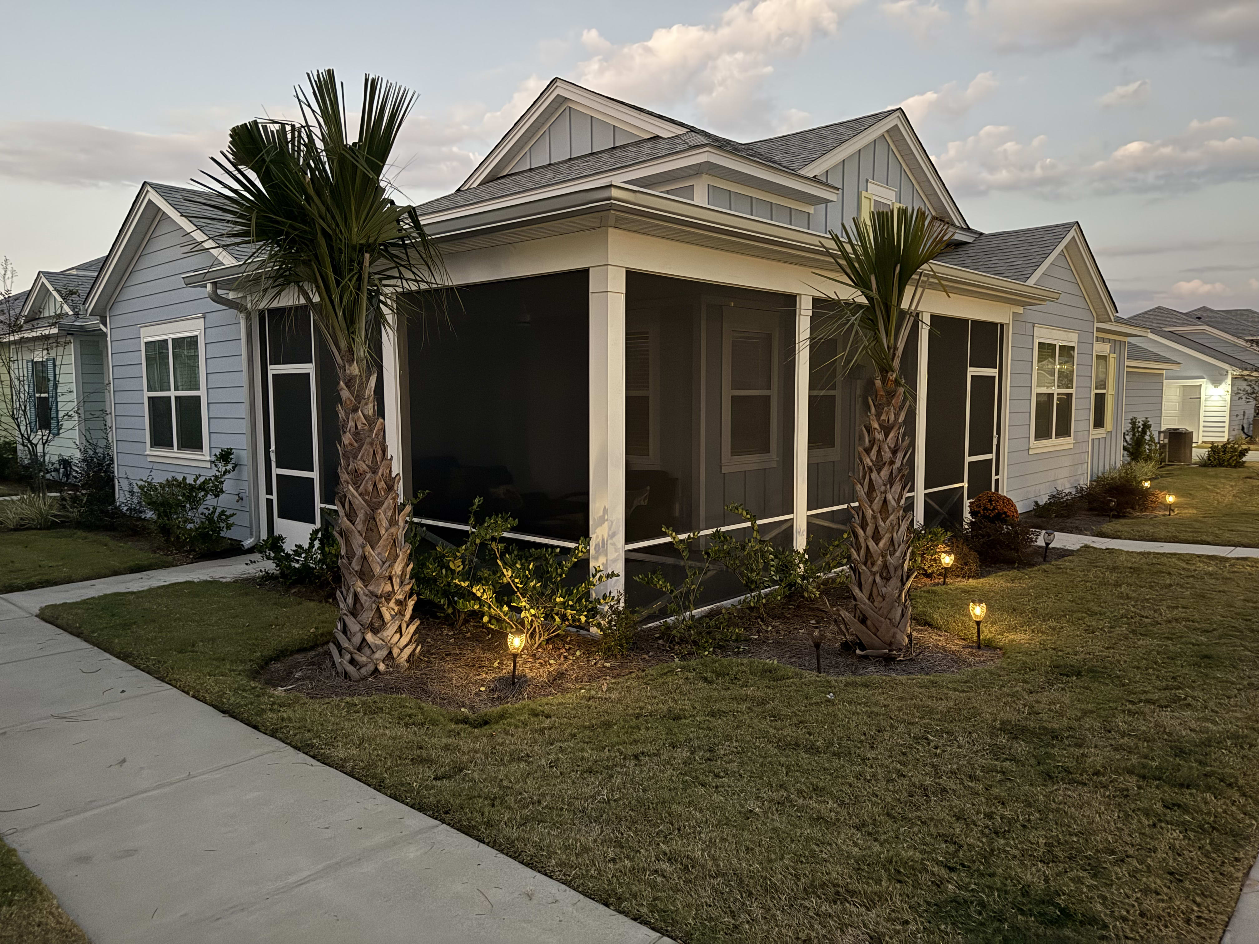 A beautiful screened enclosure with palm trees, designed for coastal living in Beaufort, SC.