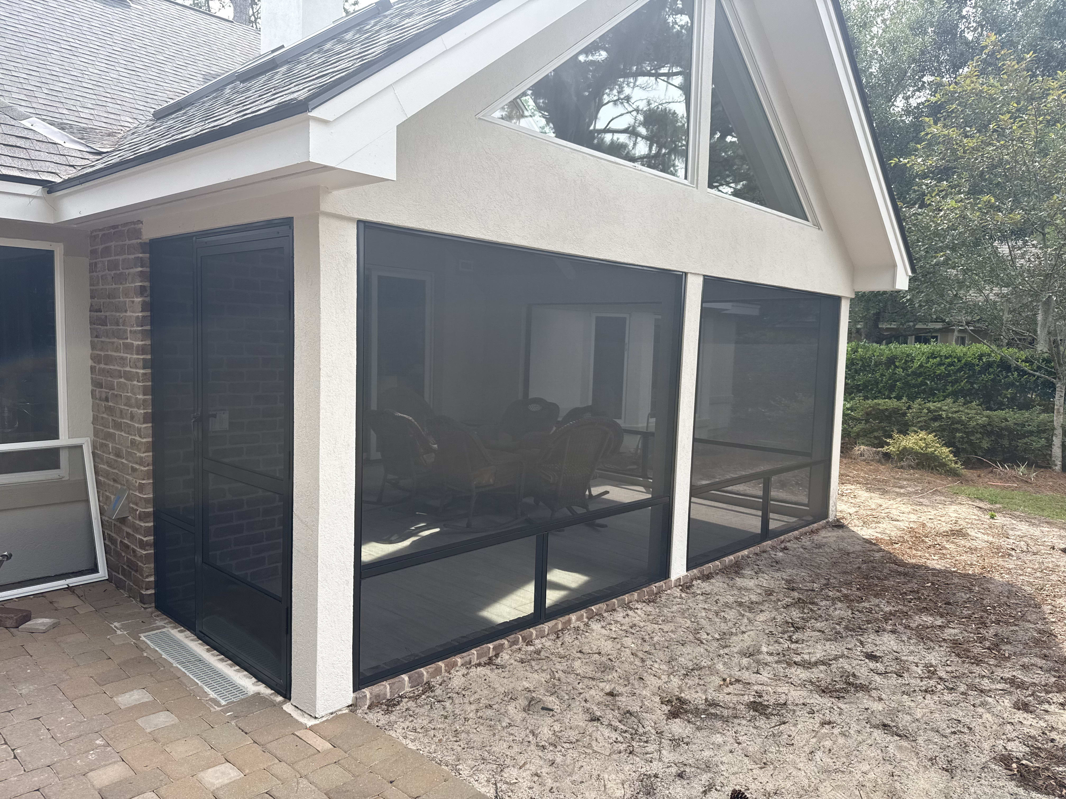 A custom screened enclosure designed for coastal living, showcasing durable aluminum framing.