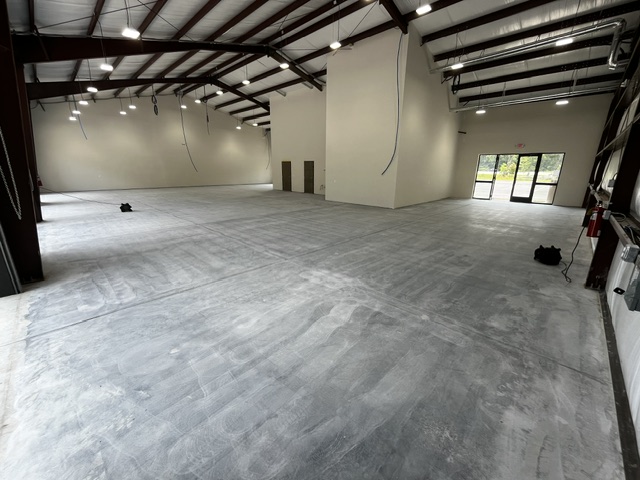 A spacious commercial flooring installation featuring a smooth gray surface and large windows in South Carolina.