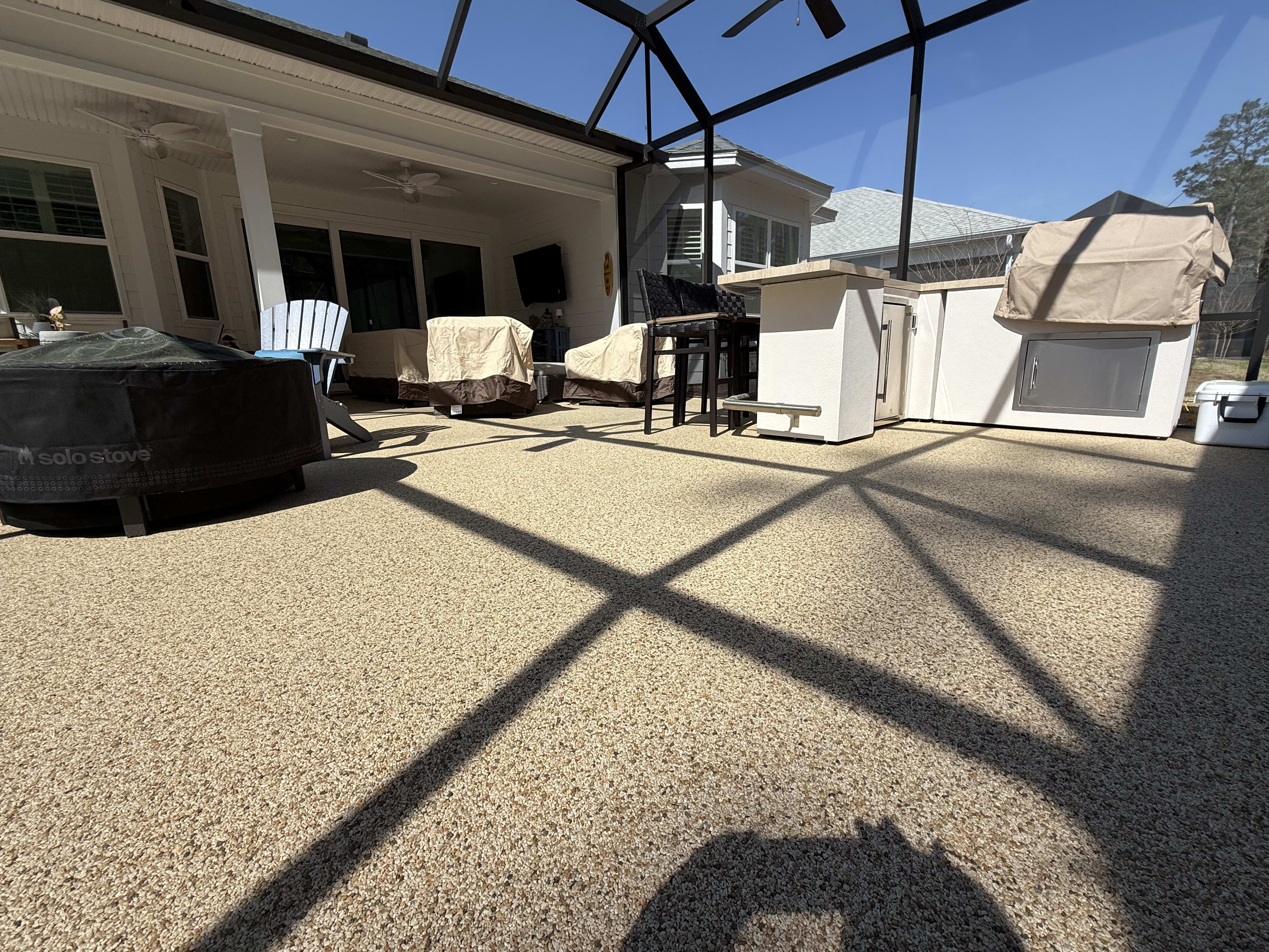A textured concrete floor in a screened patio with seating and a bar area in South Carolina.