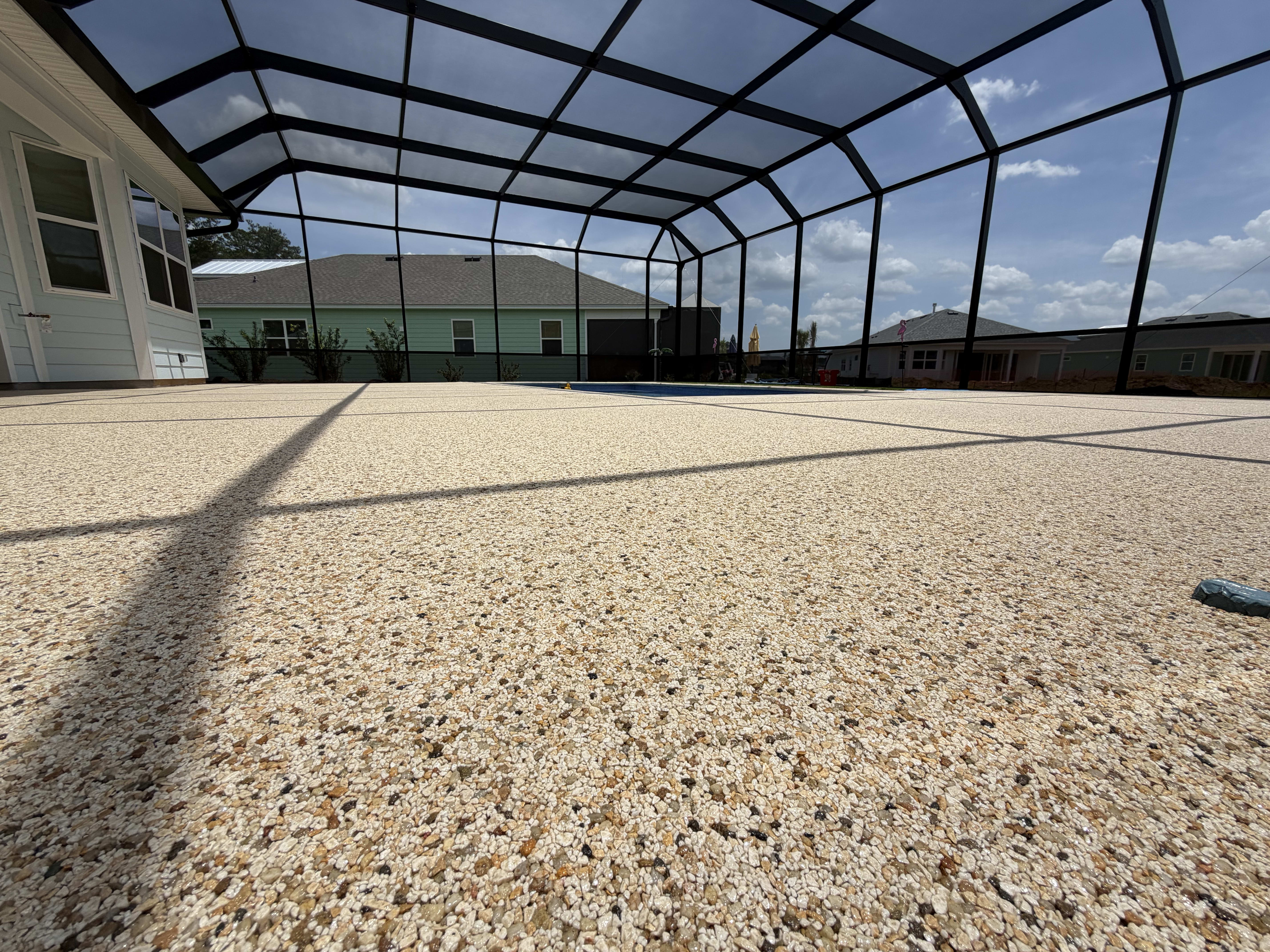 Textured concrete floor inside screened pool enclosure