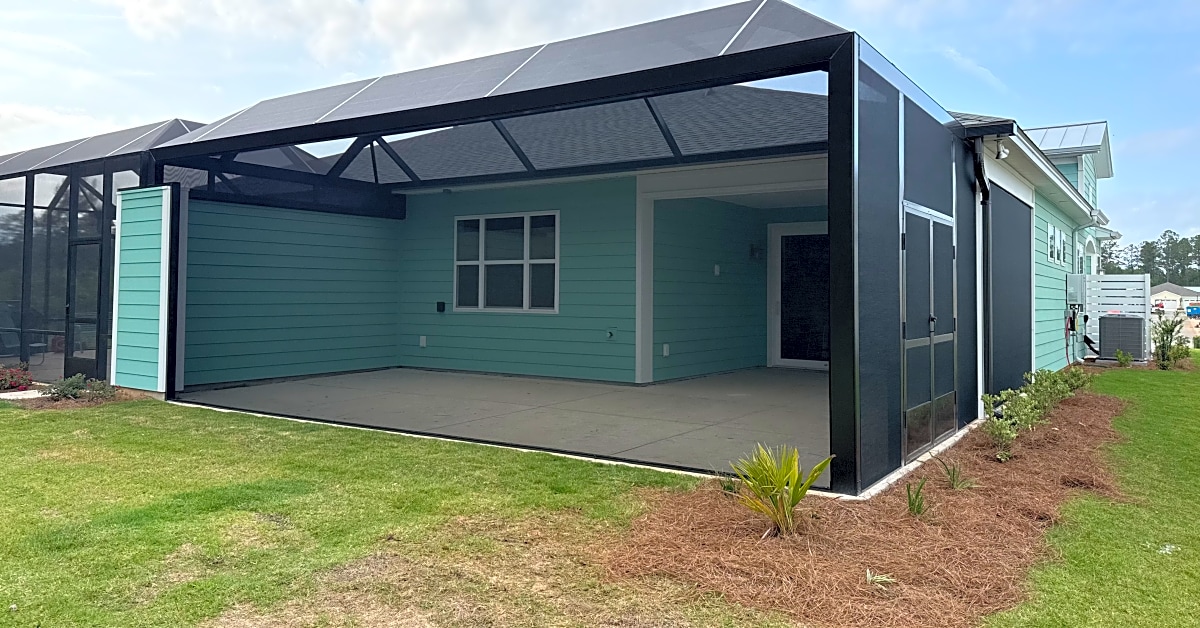 A black screened enclosure featuring green siding and a spacious interior in South Carolina.