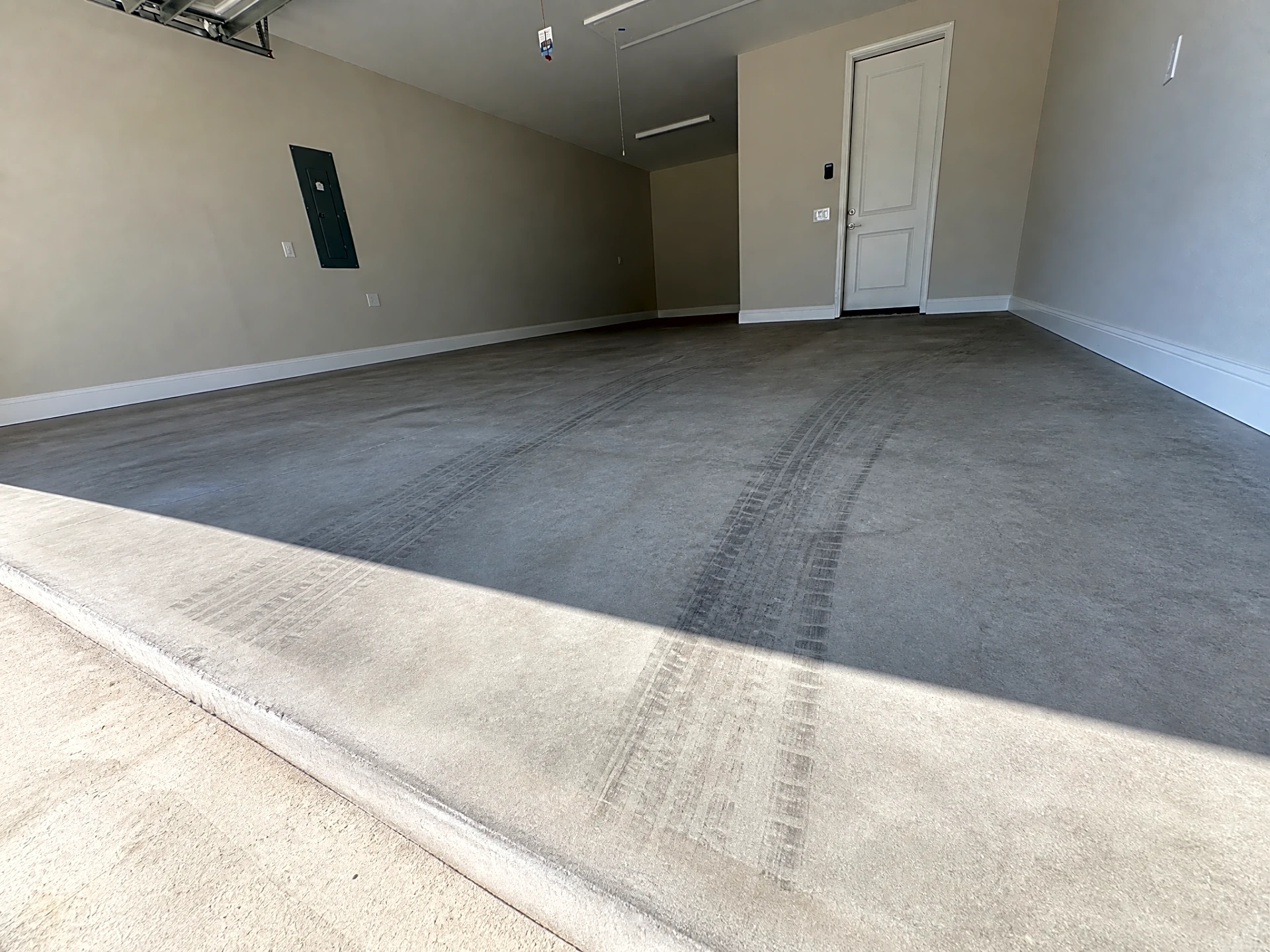 A clean garage floor with tire tracks prior to preparation in Bluffton, SC.