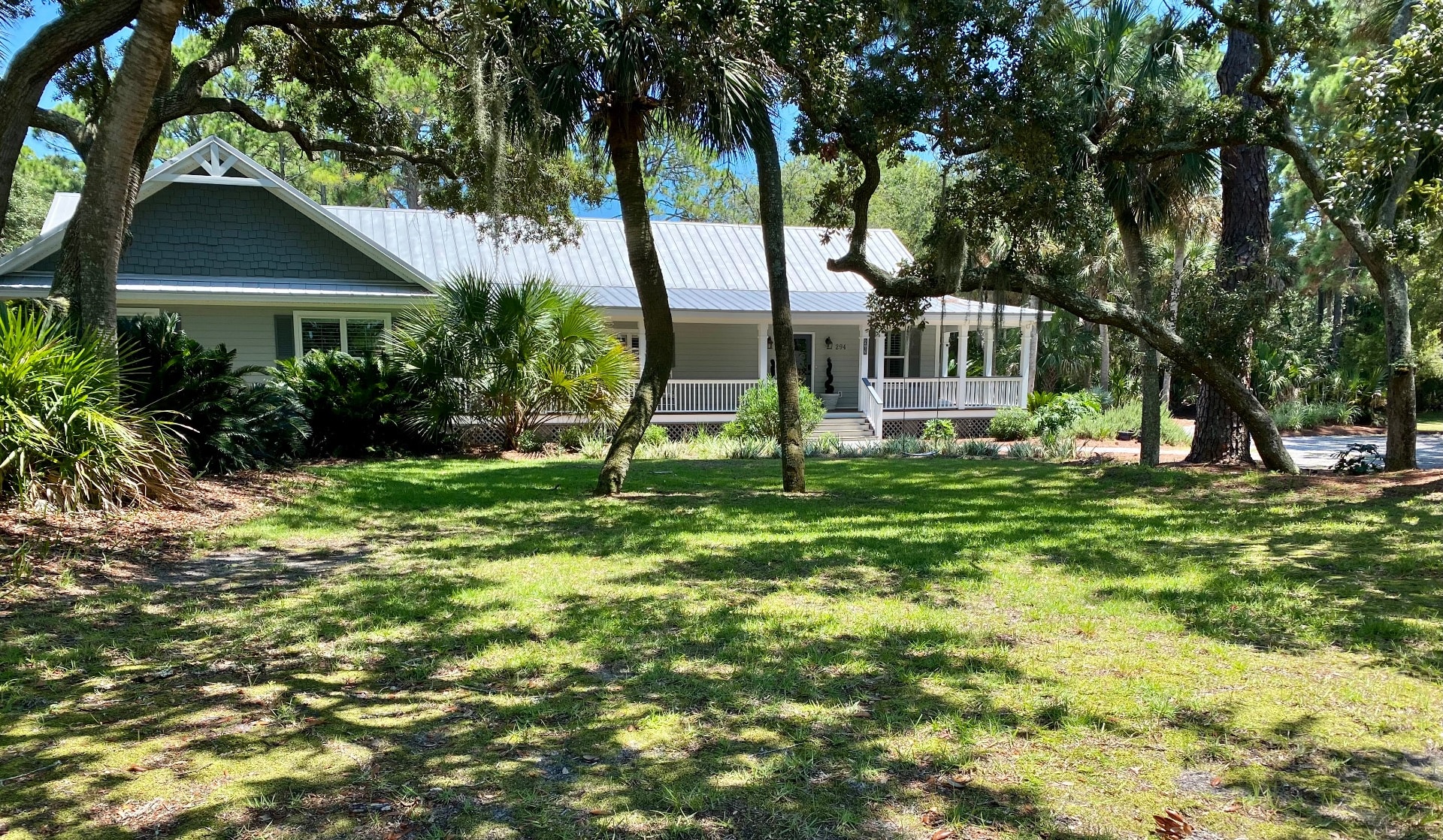 Front of Home facing the marsh among the tangled oaks & palms