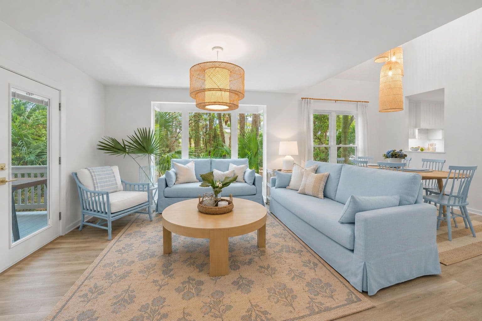 Bright Lowcountry coastal living room with light blue sofas round wooden coffee table