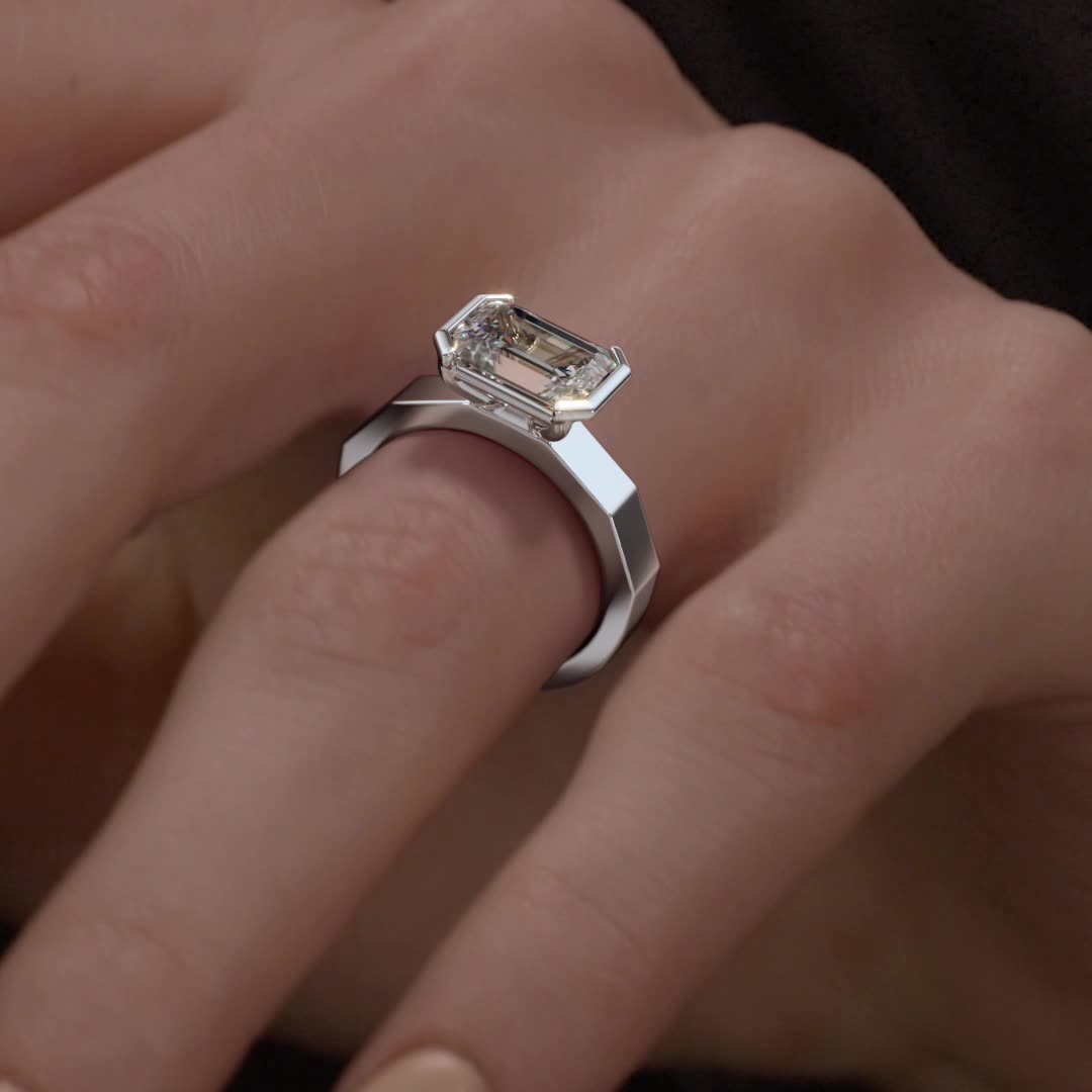 18k white gold e.w. geometric half bezel emerald solitaire engagement ring with emerald shape diamond