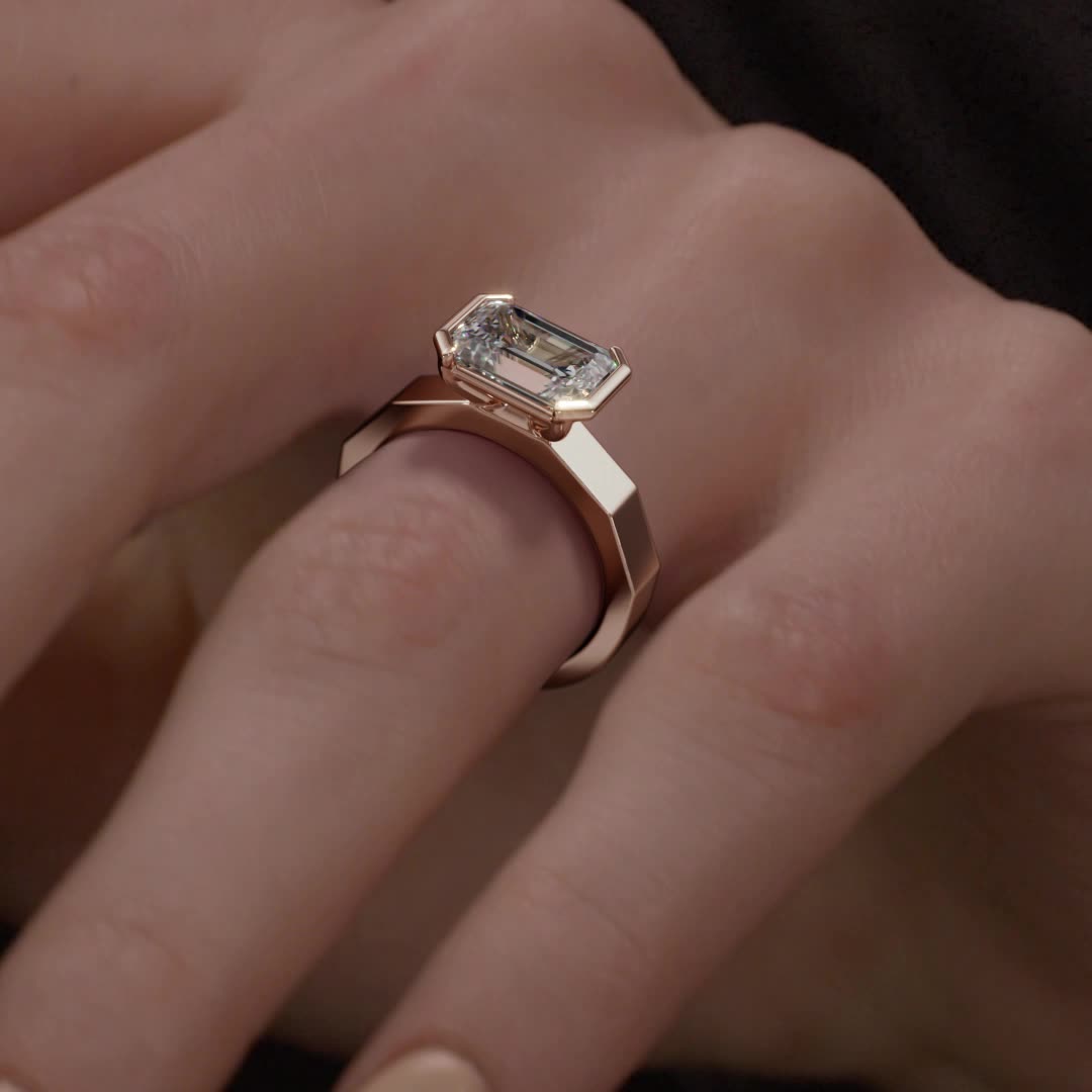 14k rose gold e.w. geometric half bezel emerald solitaire engagement ring with emerald shape diamond