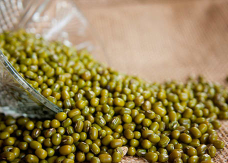 Mung beans spilling out of clear bowl