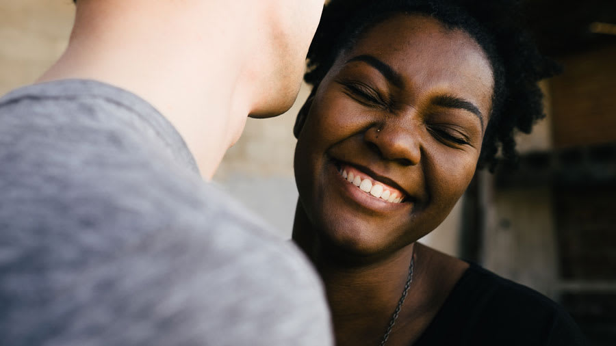 Black woman smiling with beautiful white teeth.
