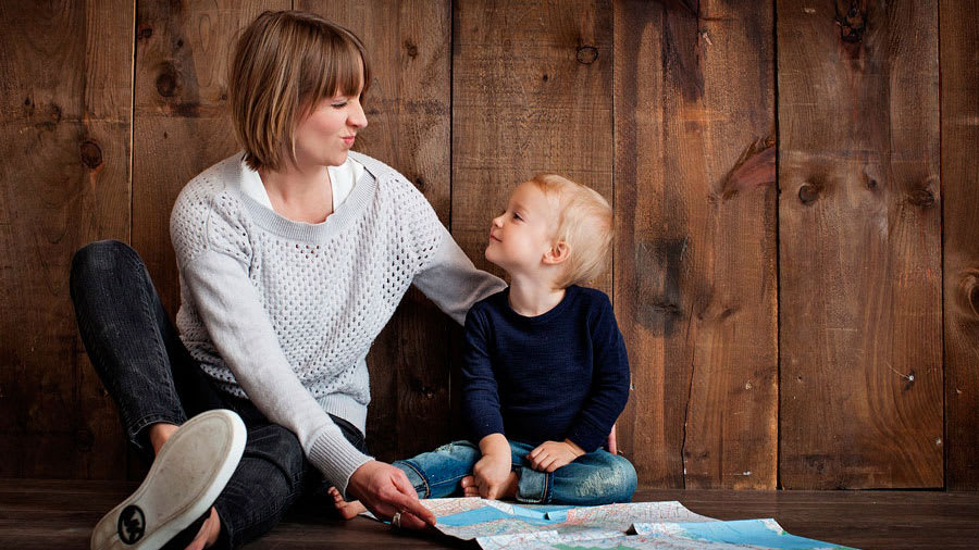 Mother sitting on the floor making faces as her son sitting on the floor next to her
