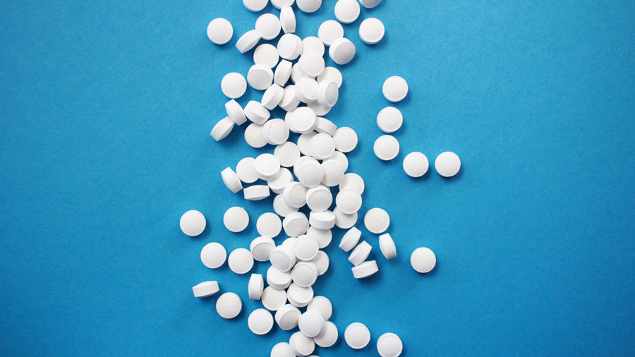 white isotretinoin pills against blue background