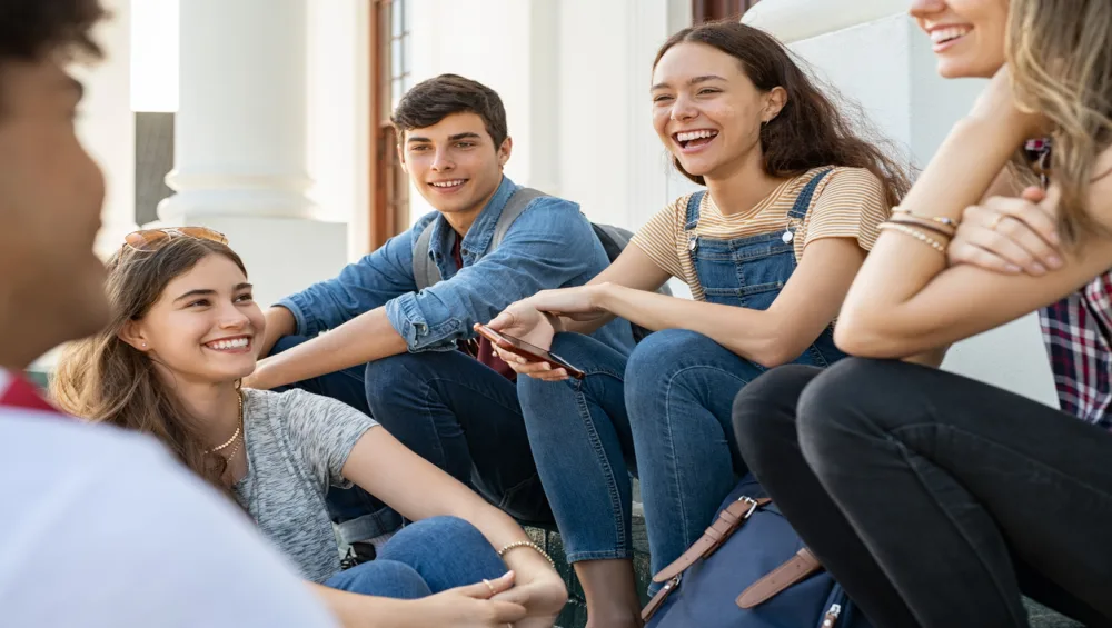 a group of teenagers sitting outside
