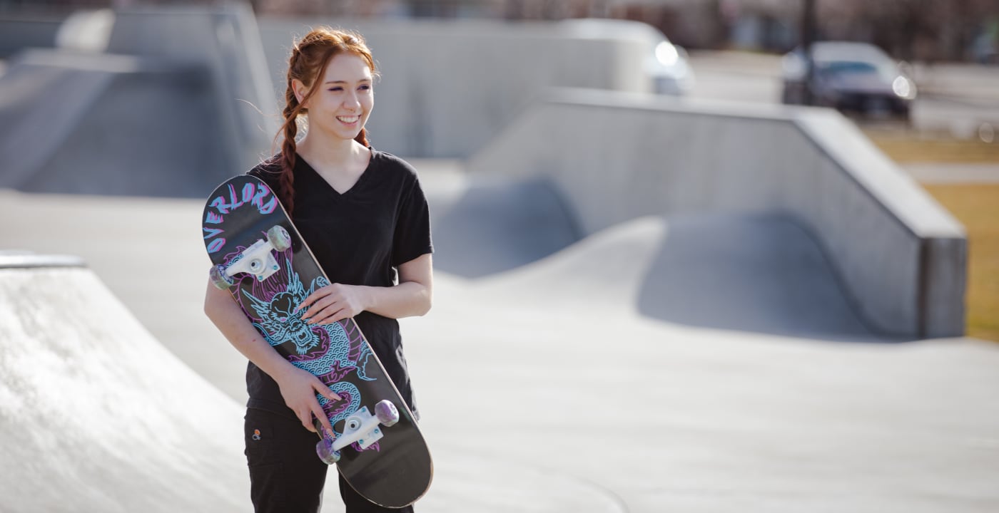 Teen girl holding a skateboard