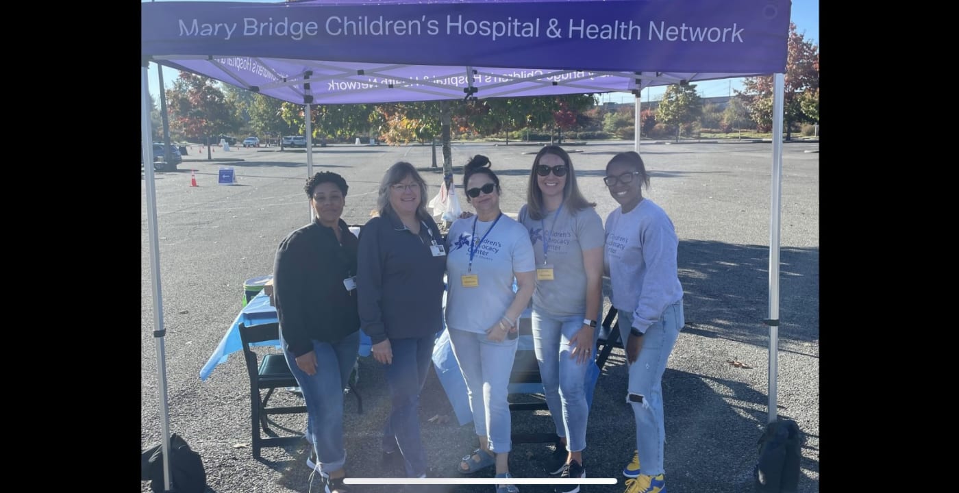 Five Mary Bridge Children’s employees standing next to one another outside under a tent