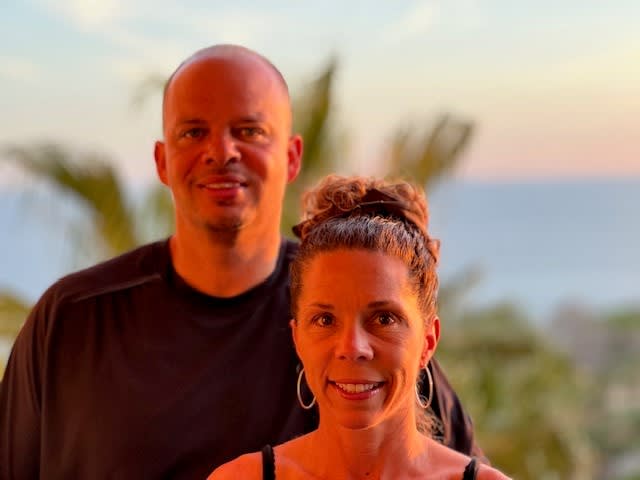 Man and woman with palm trees blurred in background