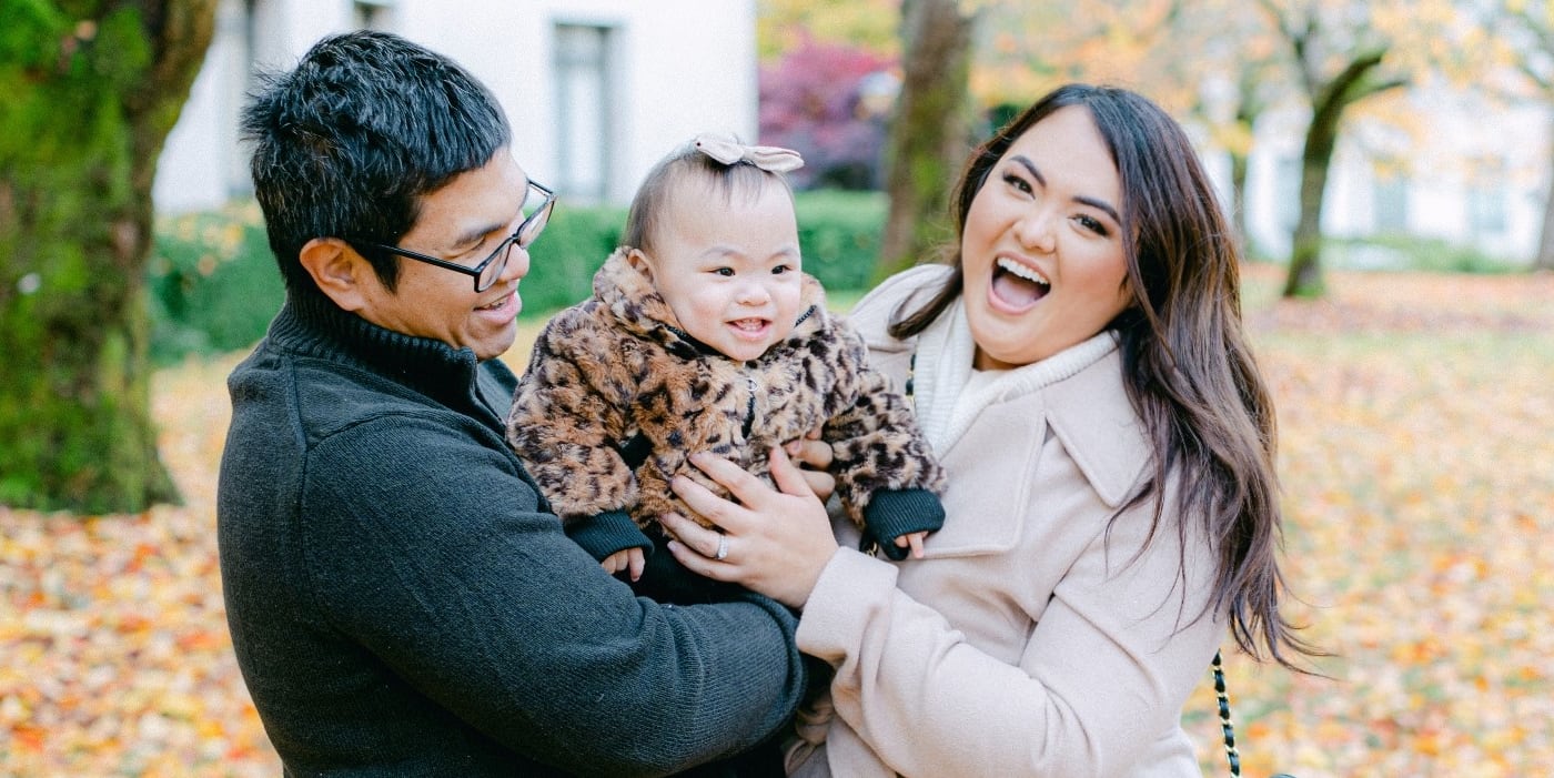 Little girl being held by parents