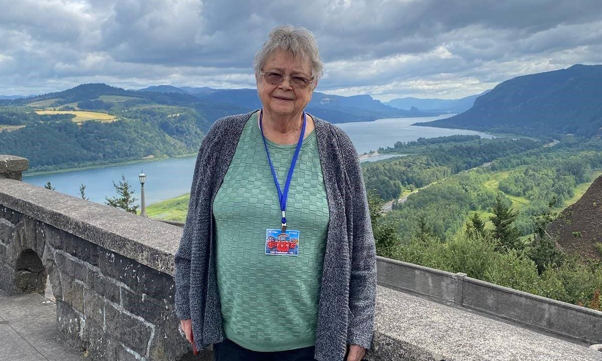 woman standing in front of scenic river viewpoint