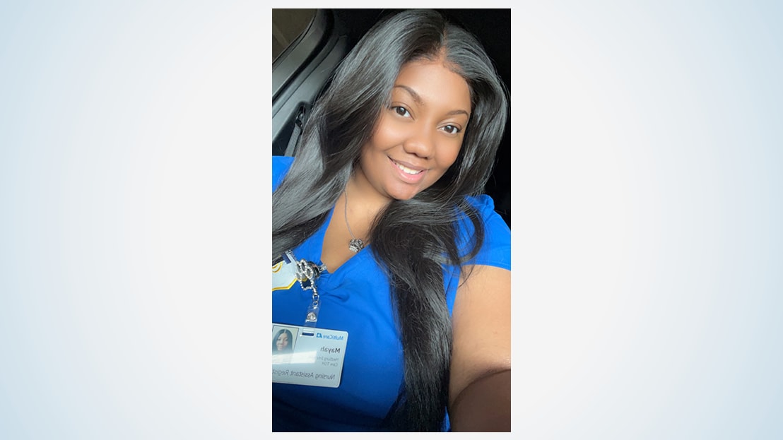 Woman in blue scrubs with long black hair