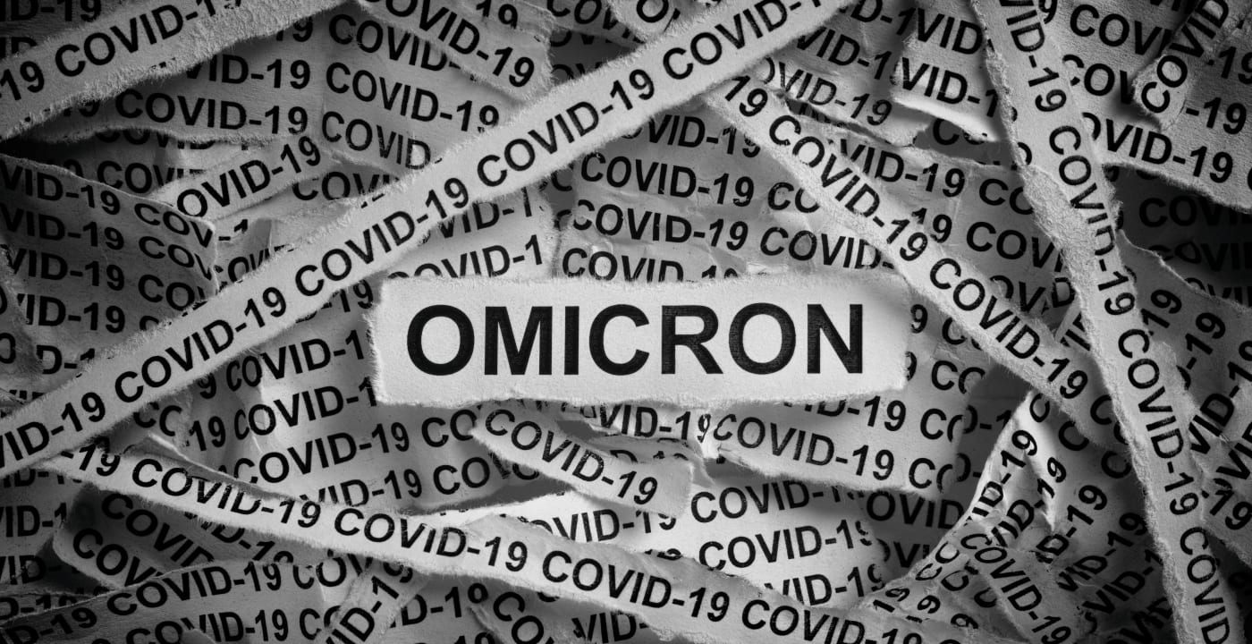 Strips of newspaper with the words Omicron and Covid-19 typed on them.