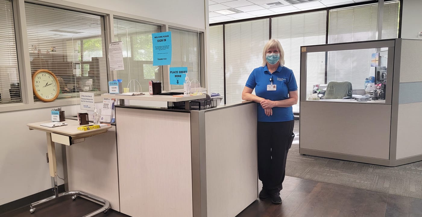 Hospital worker standing in front of a desk.