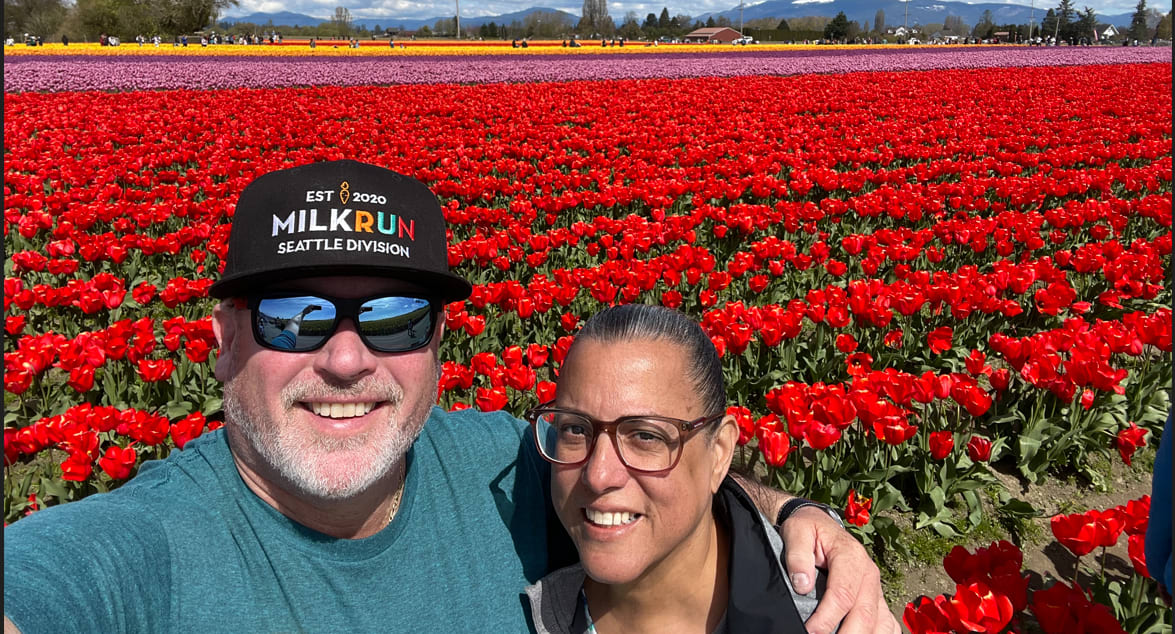 Man and woman in front of a field of red tulips