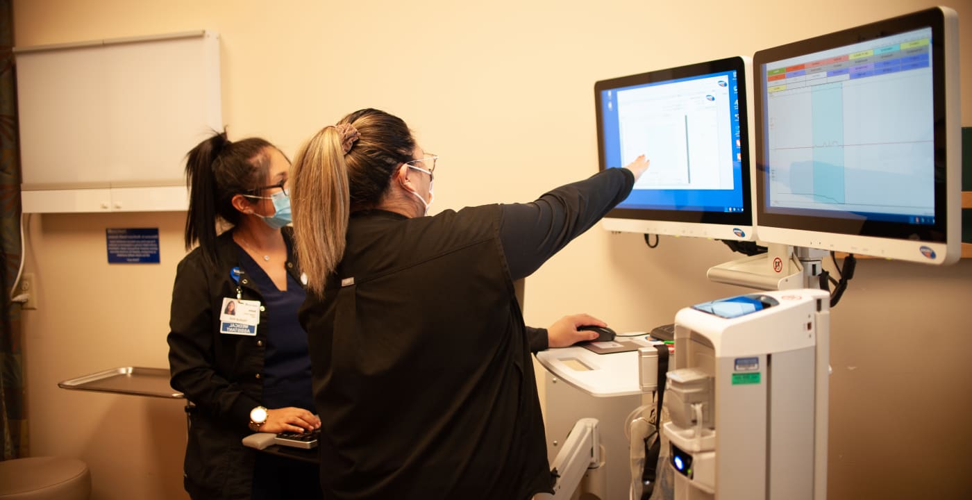 Two medical professionals looking at a screen with medical results