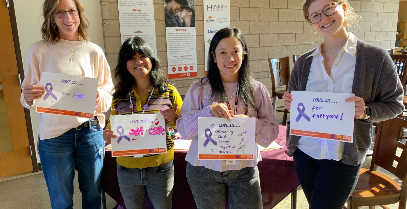 People holding domestic violence awareness signs.