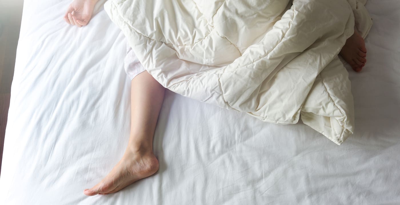 Woman sleeping in bed, feet showing