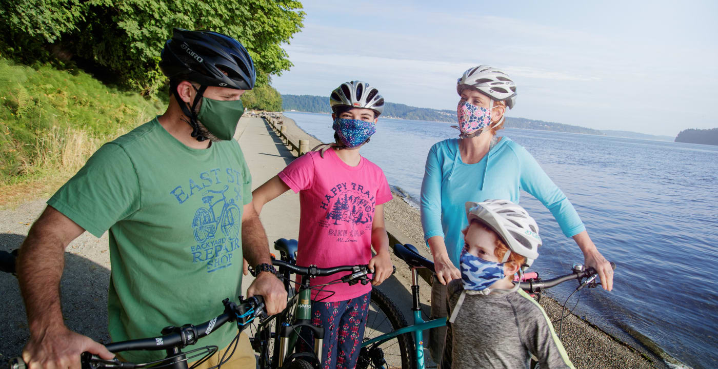 Family biking with masks on