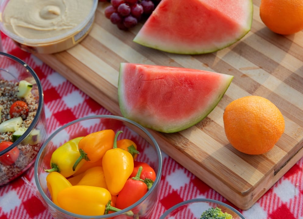 Picnic blanket spread with fruits and veggies