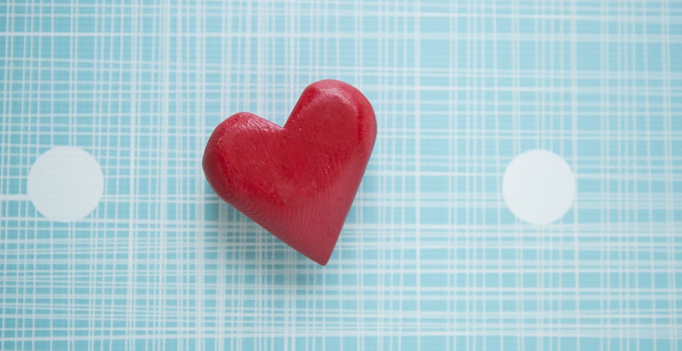 Wooden red heart on light blue and white background