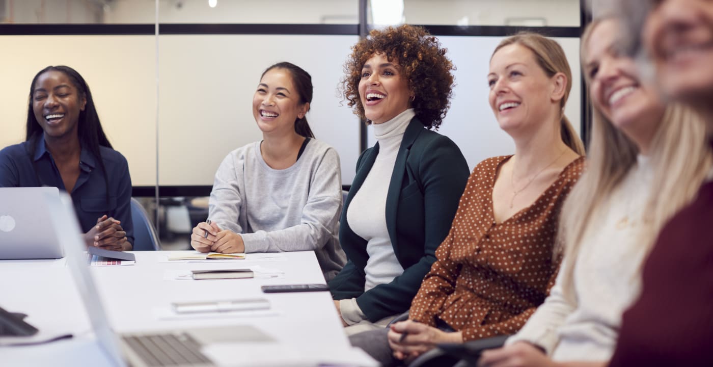 Women sitting at an office table.