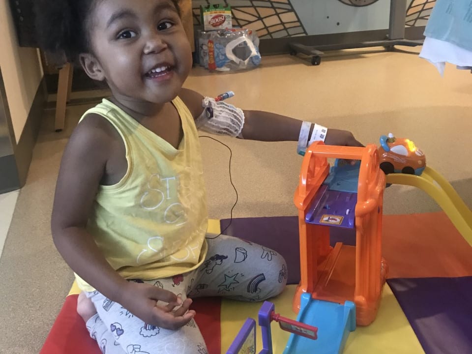 Little girl playing with toys and smiling