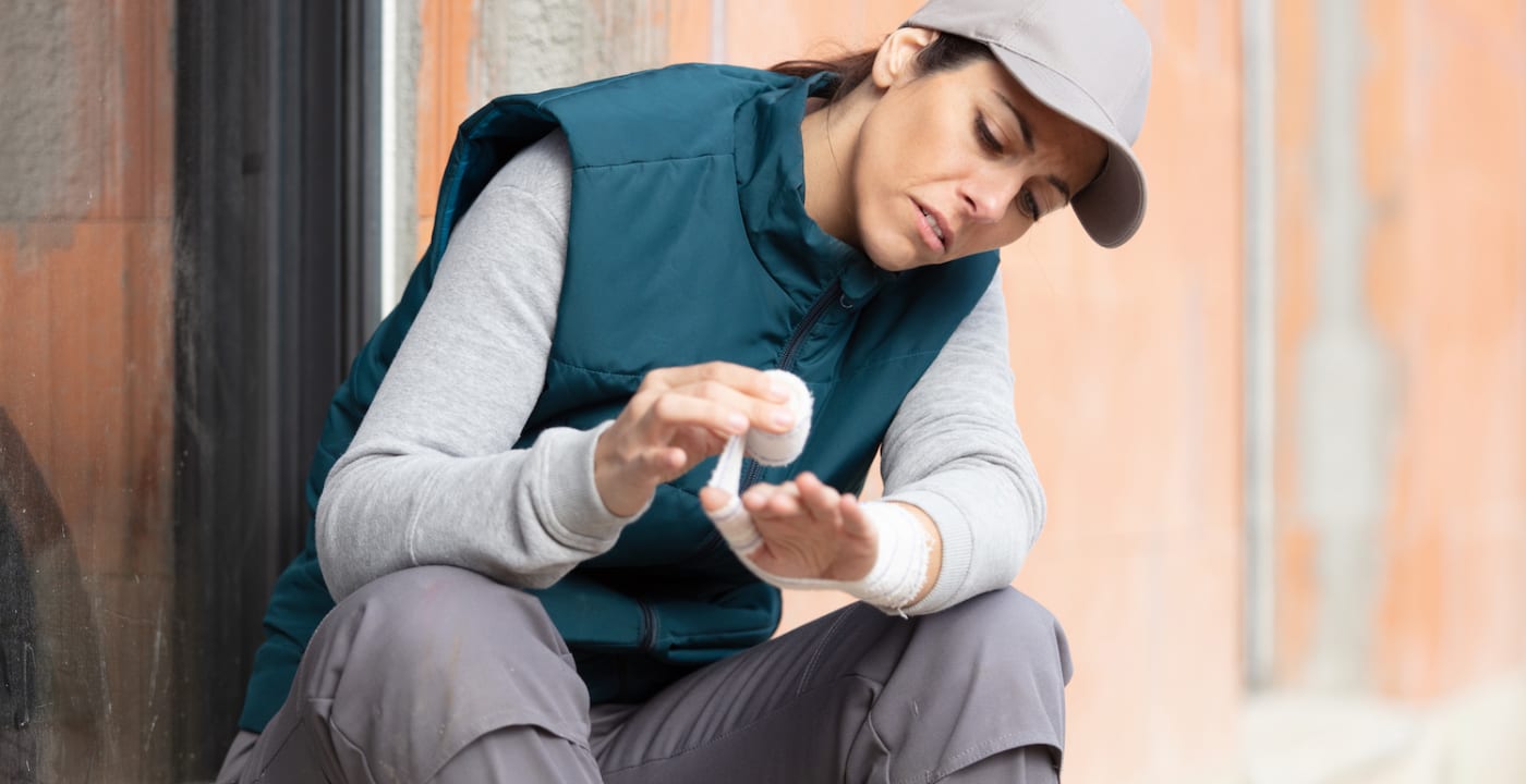 female worker bandaging her hand after incident