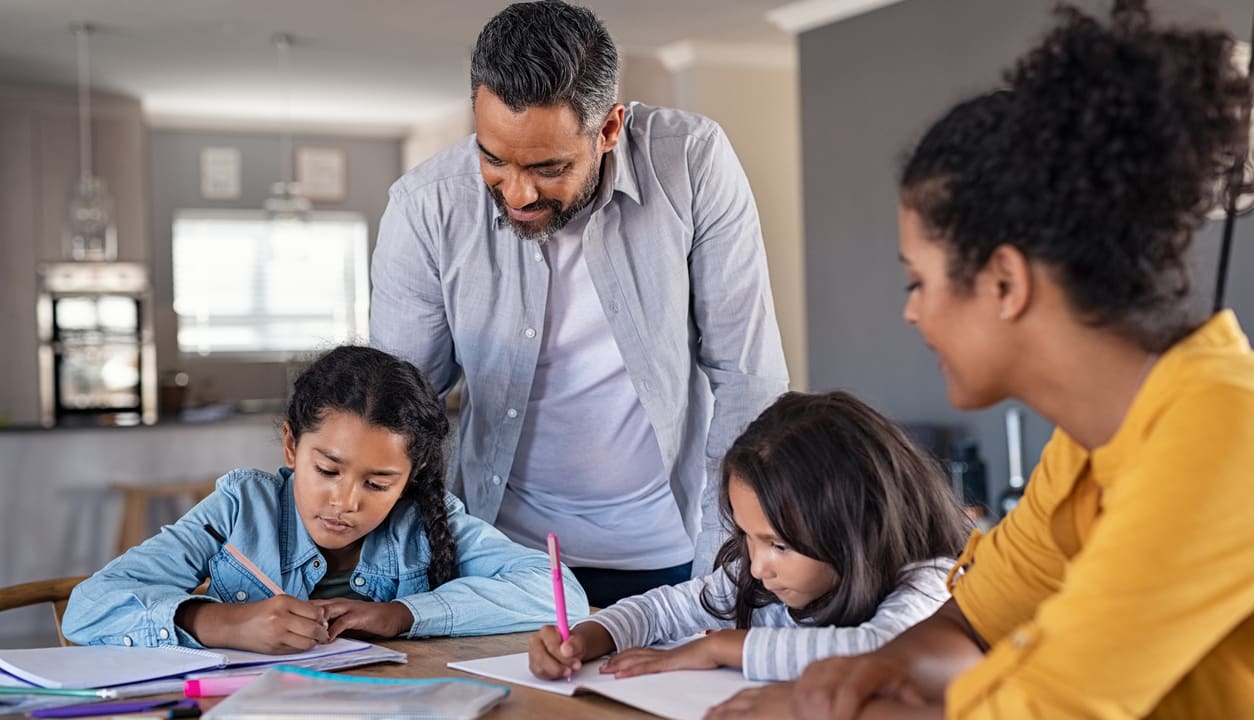 Parents watching two children doing homework